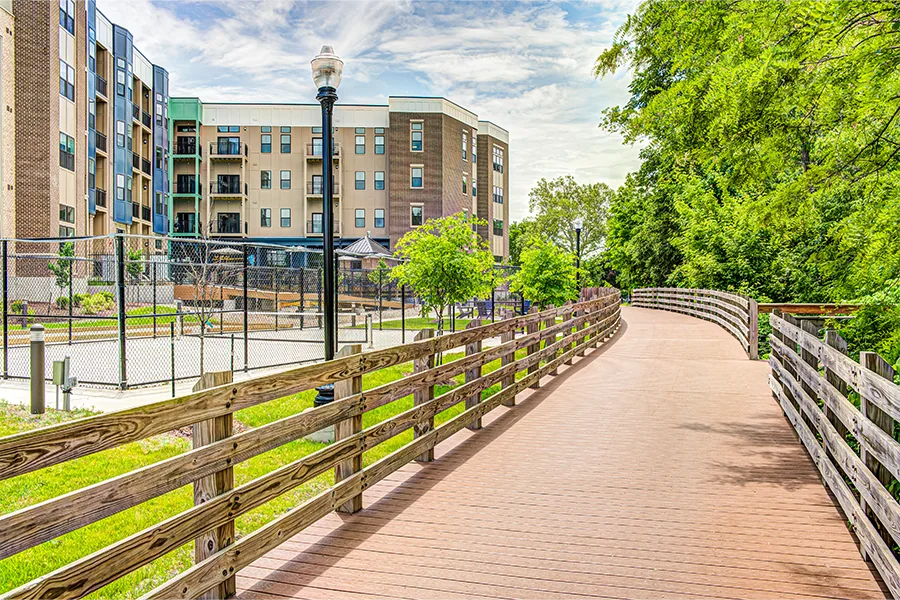 A boarded walkway and pickleball court by East Bank Apartments
