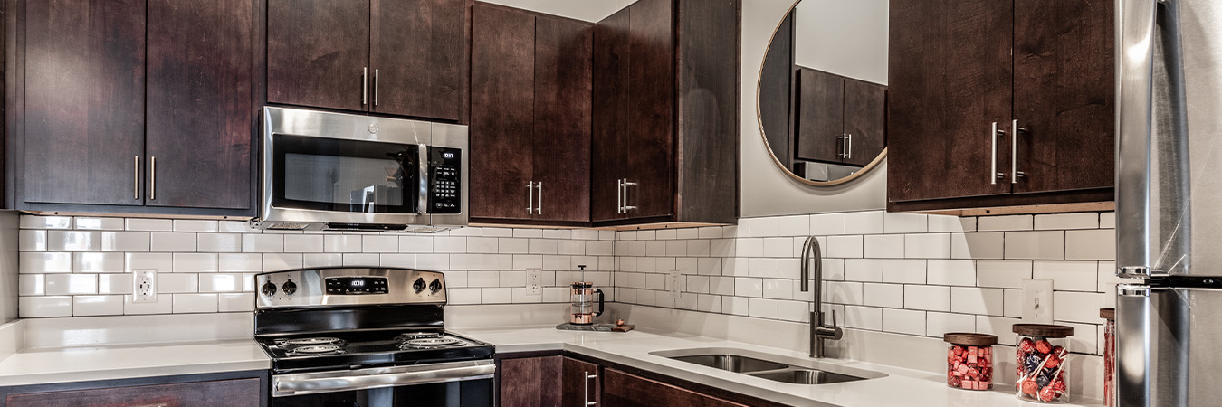 Modern kitchen with white tile backsplash located at Spark Apartments.